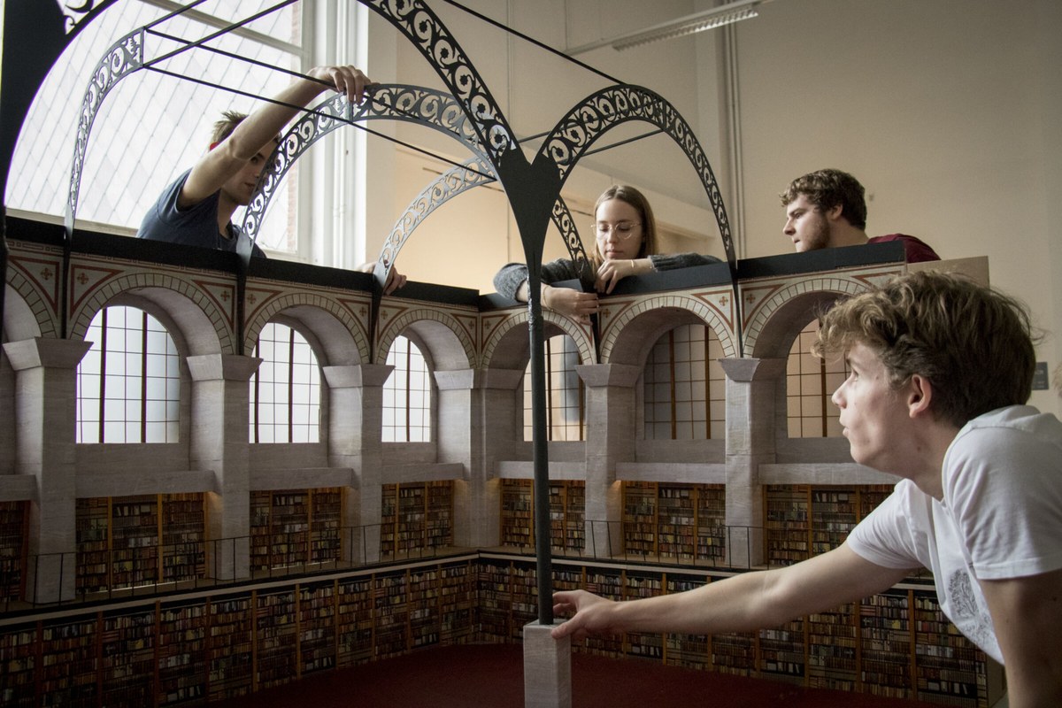 Visitors looking across an ornate historic interior with arches and railings.