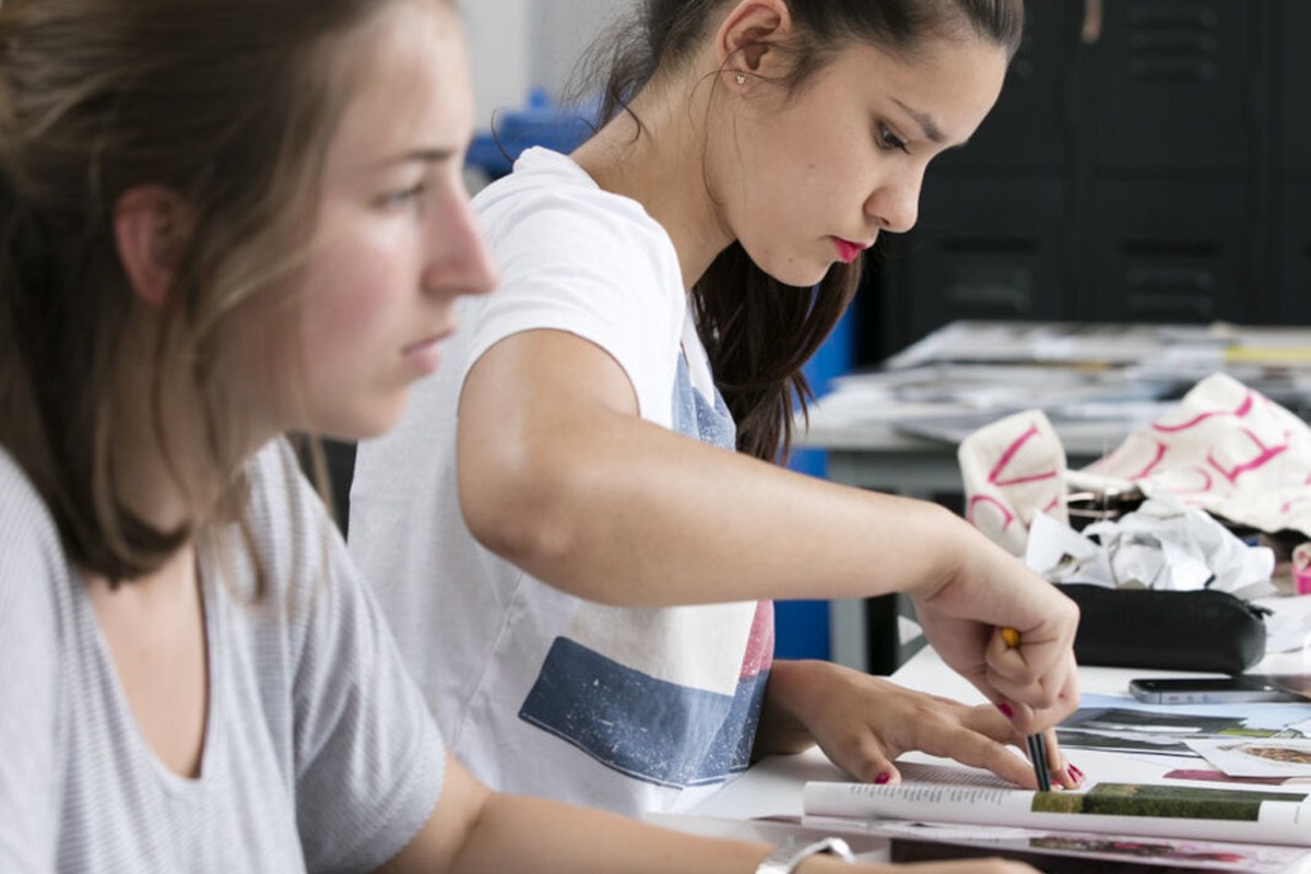 Two people working with materials at a table during a hands-on project.